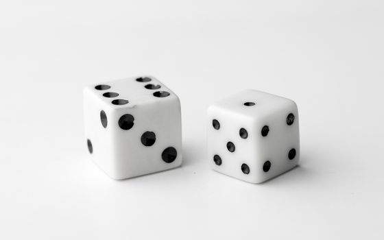 Two white dice thrown to reveal the values six and one