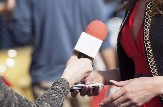 A journalist is making a interview with a microphone