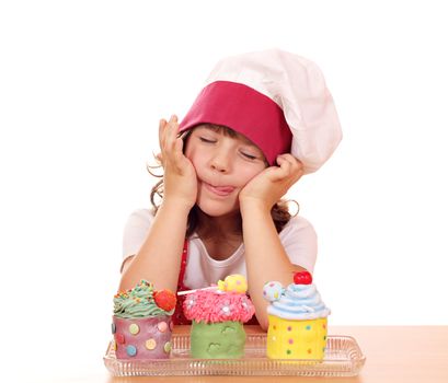 little girl cook enjoying sweet cupcakes