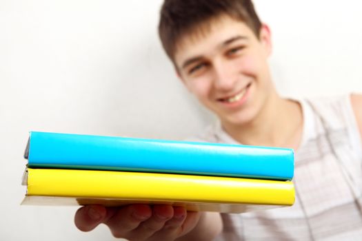 Cheerful Teenager shows Two Books. Focus on the Books