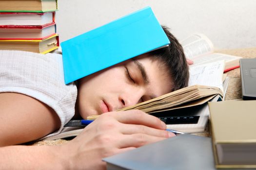 Tired Teenager sleeps after Learning on the Sofa with the Books