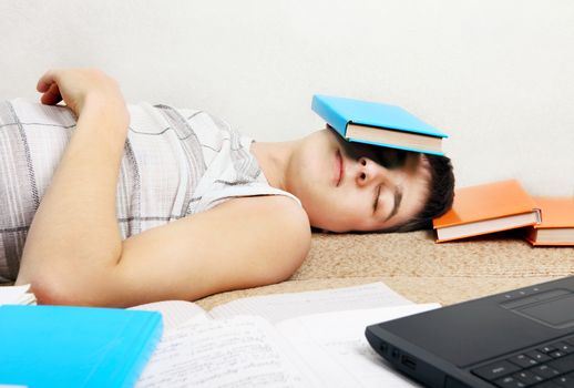 Tired Teenager sleeps after Learning on the Sofa with the Books