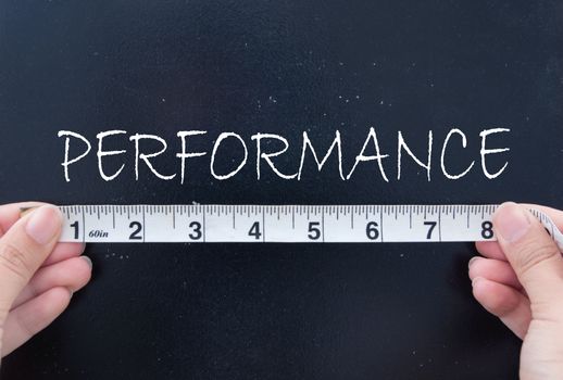 Tape measurement of the word performance on a chalkboard 