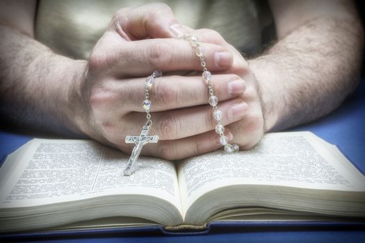 Christian believer praying to God with rosary in hand