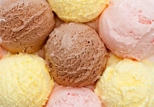 Scoops of different flavored icecream including vanilla, strawberry and chocolate 