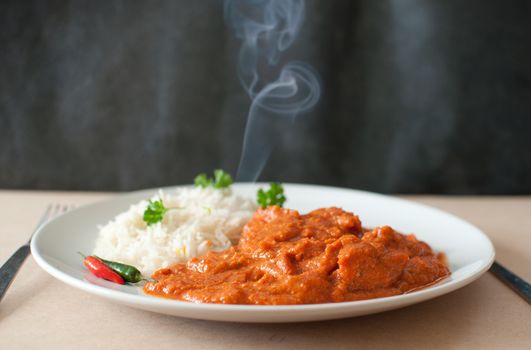 Chicken curry on a plate with rice an chilli pepper 
