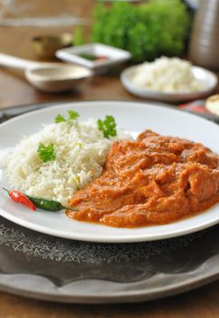 Chicken curry on a plate with rice an chilli pepper 