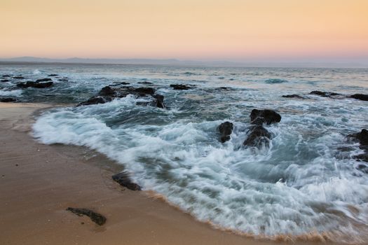 Rough sea and sunset at the rugged coast in South Africa