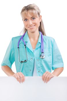 beautiful smiling toothy female doctor looking at camera and holding white plackard isolated on white