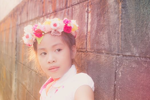 beautiful little girl with flowers on the head, vintage texture 