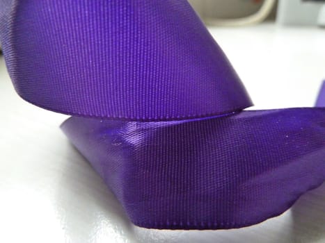 Bright piece of purple ribbon curled on a surface