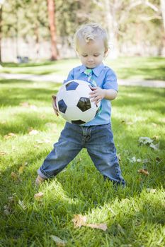 Young Cute Boy Playing with Soccer Ball in the Park.