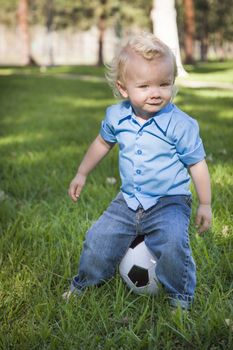 Young Cute Boy Playing with Soccer Ball in the Park.