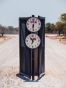 Campsite gate with marked opening and closing time (Halali, Etosha National Park, Namibia)