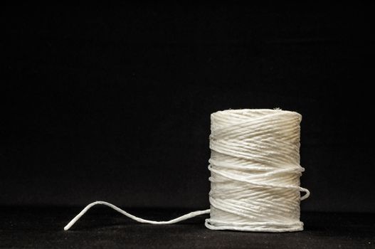 Roll of White Twine on a Black Background