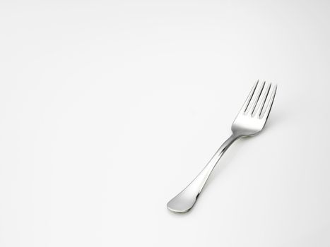 very shiny steel fork over white background 