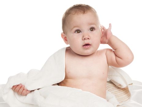 Beautiful child sitting wrapped in towel. Isolated on white background