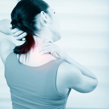 young brunette woman with a pain in the neck, monochrome photo with red as a symbol for the hardening