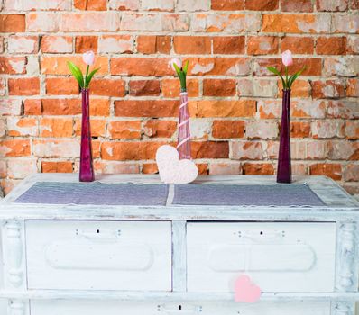 pink hearts and flowers on a background of red bricks