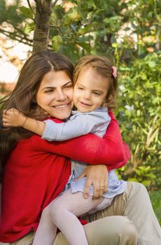 Mother and daughter hugging in the park.