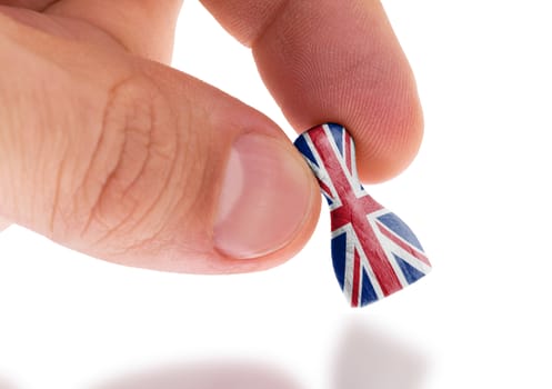 Hand holding wooden pawn with a flag painting, selective focus, United Kingdom