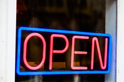 Glowing open neon sign in a window