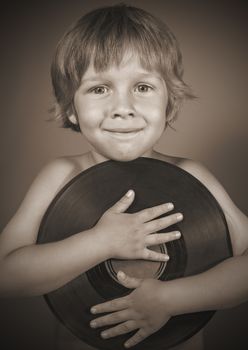 A boy with a record smiles