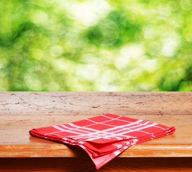 Empty wooden table and fresh green bokeh bubbles in background