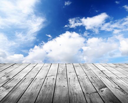 Empty wooden table and summer cloudy sky in background