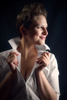 Proud young woman against black background in studio