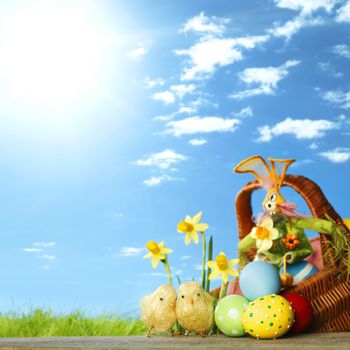 Easter card with eggs and daffodils over spring grass background