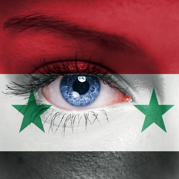Woman face painted with flag of Syria
