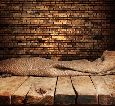 Empty wooden table and brick wall in background