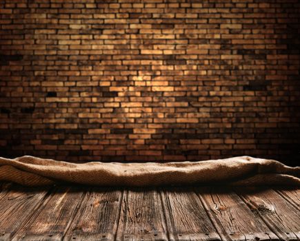 Empty wooden table and brick wall in background