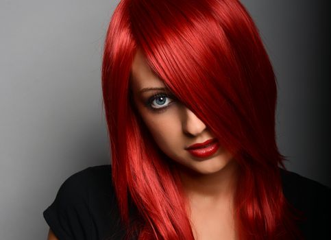 Beautiful red haired girl over gray background