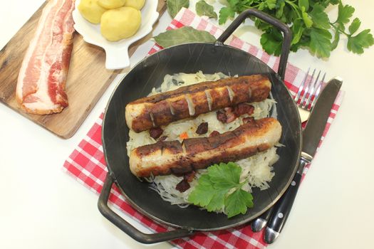 a pan with sourcrout and fried sausage