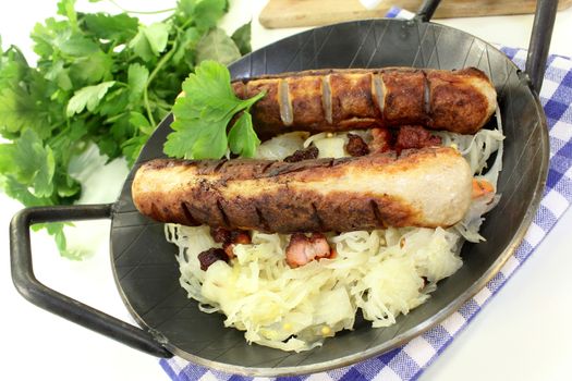 a pan with sourcrout and fried sausage