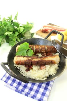 a pan with sourcrout and fried sausage