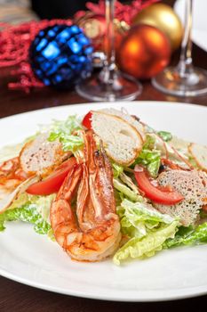 Tasty shrimp salad with vegetables on christmas table