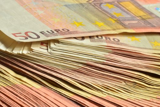 Few thousands euro in fifty euro banknotes stacked together as financial background.