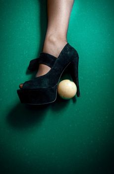 White billiard ball stuck in high heel black shoe