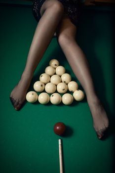 Billiard ball aiming at sexy women legs in stockings