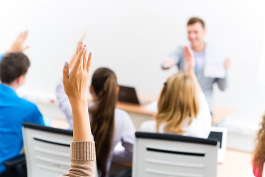 image of a female hand raised in university classroom