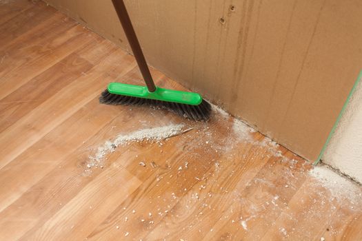 Cleaning debris on floor by brush