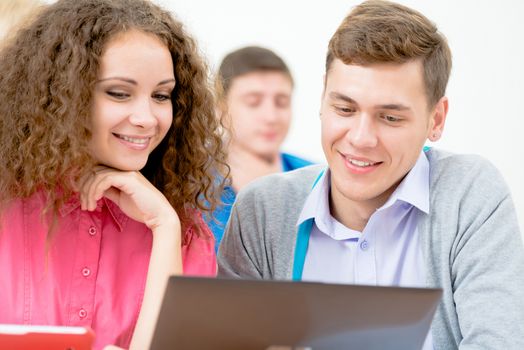 students together to discuss the lecture, come together, looking at laptop monitor