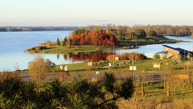 Picturesque autumn landscape of river and bright trees and bushes