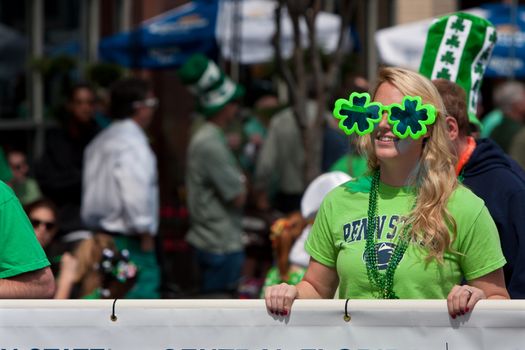 Atlanta, GA, USA - March 15, 2014:  A woman wearing shamrock sunglasses carrries a banner down Peachtree Street as part of the St. Patrick's parade. 