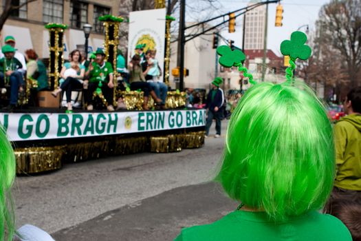 Atlanta, GA - March 15, 2014:  A woman wearing a green wig watches a parade float go by at the annual St. Patrick's parade.