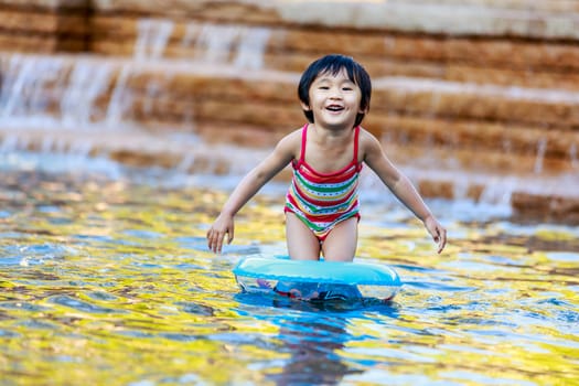 Adorable girl plays water in the park