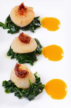 sea scallops with spinach and tomatoes close-up